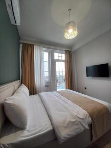 a bedroom with a large white bed and a window at Grey House in Yerevan +101 photos