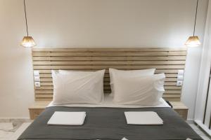 Un dormitorio con una cama con dos almohadas blancas. en Ella apartments, en Parga