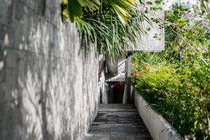 a concrete hallway with plants on the side of a building at Blossom Eco Luxe Villas by Ekosistem in Canggu