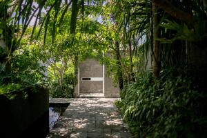 a stone path leading to a door in a jungle at Blossom Eco Luxe Villas by Ekosistem in Canggu