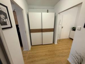 a hallway with white cabinets and a wooden floor at Apartament Nati in Cieszyn