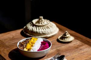 a wooden table topped with different types of desserts at Blossom Eco Luxe Villas by Ekosistem in Canggu