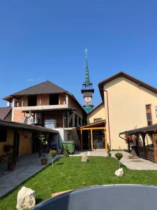 a group of buildings with a clock tower in the background at Casa Pop in Săpânța