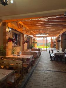 a restaurant with wooden tables and benches in a building at Casa Pop in Săpânța