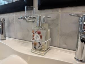 eine Flasche Seife auf einem Waschbecken in der Unterkunft Serene waterfront escape! Luxury, King bed! in Durbanville + 49 Fotos