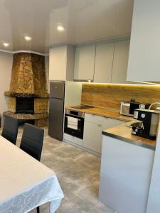 a kitchen with a stove and a stone fireplace at Sunny House in Madzhare +7 photos