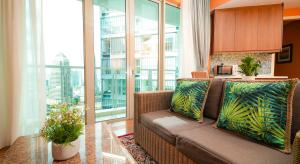 a living room with a couch and large windows at Acappella Kuala Lumpur City Centre in Kuala Lumpur