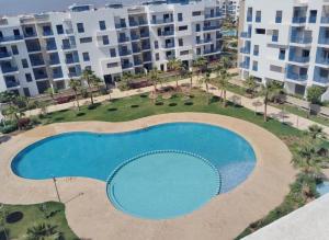 an overhead view of a swimming pool in front of buildings at Martil Playa Haut standing in Martil
