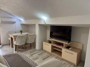 a living room with a table and a flat screen tv at Apartments Slavica in Ohrid