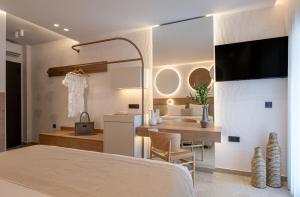 a bedroom with a bed and a table and a kitchen at Olenia Suites in Neos Marmaras