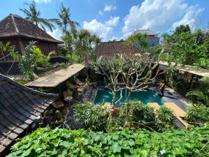 ウブドにあるNingmas Garden By Sidhi Hospitality Experiencesのスイミングプール付きの庭園の空中ビュー