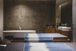 a bathroom with two beds and a tub and a sink at Blossom Eco Luxe Villas by Ekosistem in Canggu