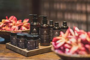 a group of four bottles of hair products and a bowl of fruit at Blossom Eco Luxe Villas by Ekosistem in Canggu