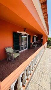 eine Veranda eines Hauses mit einer Bank darauf in der Unterkunft Quinta dos Moledros in Figueira