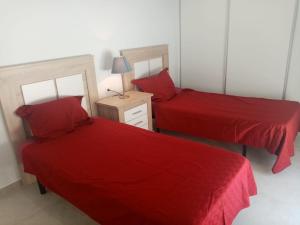 two beds in a room with red sheets at Villa San Benito in Los Montesinos +29 photos