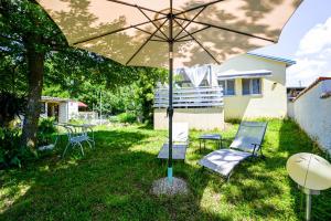 a patio with chairs and an umbrella in the yard at Helena Garden House in Kanfanar