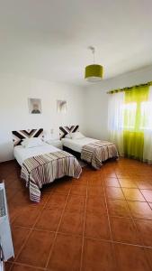 zwei Betten in einem großen Zimmer mit Holzboden in der Unterkunft Quinta dos Moledros in Figueira + 4 Fotos