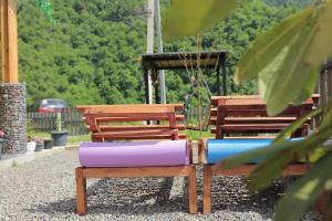 a park bench with a purple and blue pillow at Woodlandia Borjomi with Hot Tub and Private Garden in Borjomi