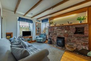 un soggiorno con divano e camino in pietra di Fisherman's Cottage in Pennan a Pennan