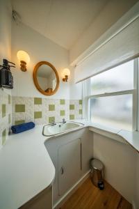 un bagno con lavandino e specchio di Fisherman's Cottage in Pennan a Pennan