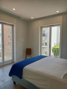 a bedroom with a large bed and two large windows at Brezza Marina in Massa Lubrense