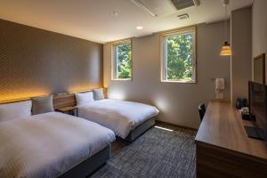 Voodi või voodid majutusasutuse Kiryu Grand Hotel toas