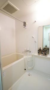 a bathroom with a bath tub and a mirror at 1min to Nakajima Park, max 6 ppl, 2LDK, 2 double bed, 1 sofa bed, Sapporo in Sapporo +68 photos