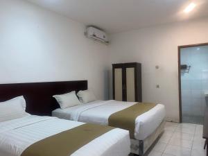 Кровать или кровати в номере Hotel Netral Jombang