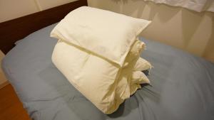 a pile of white pillows on a bed at 1min to Nakajima Park, max 6 ppl, 2LDK, 2 double bed, 1 sofa bed, Sapporo in Sapporo