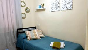 a bedroom with a blue bed with two pillows at Habitaciones en Luisa in Madrid