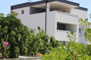 een wit gebouw met bomen ervoor bij Villa SEVEN in Vir