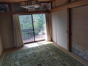 a room with a large window with a rug in front of it at 民泊SakuraワンちゃんＯＫ in Karatsu +4 photos