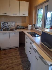 a kitchen with white cabinets and a counter top at Domek Zapach Wyspy in Gdańsk