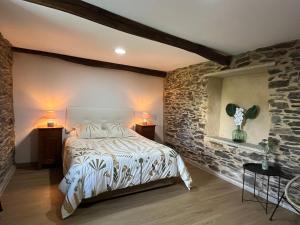 a bedroom with a bed and a stone wall at Casa rural entre Santiago Compostela y La Coruña in Ordes