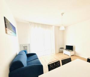 a living room with a blue couch and a television at Maredena - Comodo al centro e al Mare - Immobil Relax in Lido di Jesolo +2 photos