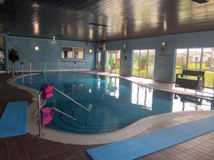 a large swimming pool in a building at 39 Perran View Your Home Away from Home in Cornwall in St. Agnes