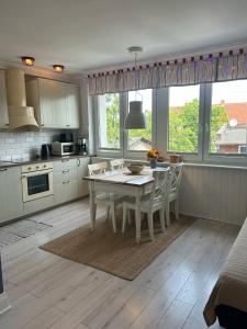 a kitchen with a table and chairs in a room at Apartament Heljan, 150 m od plaży in Gdańsk