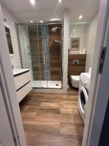 a bathroom with a shower and a washing machine at Apartament Heljan, 150 m od plaży in Gdańsk