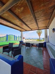 a patio with chairs and a table and a tennis court at Aquilone Residence in Stromboli
