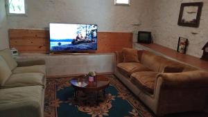 a living room with a couch and a flat screen tv at Rincon de Valdaliga in Valdaliga 
