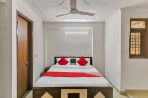 a bedroom with a bed with red pillows at Hotel O South Plaza in New Delhi