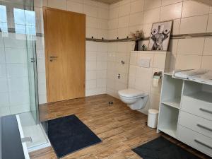 a bathroom with a toilet and a glass shower at Ferienwohnung Zur Ochsenweid in Furth im Wald