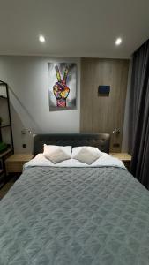 Un dormitorio con una cama grande con una mano en la pared. en HERMES Cityview Apartment, en Chişinău