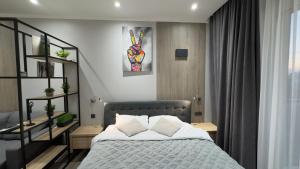 a bedroom with a bed with white sheets and pillows at HERMES Cityview Apartment in Chişinău