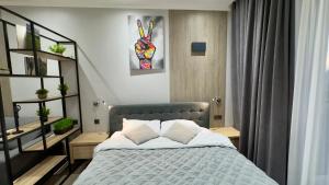a bedroom with a blue bed with two pillows at HERMES Cityview Apartment in Chişinău