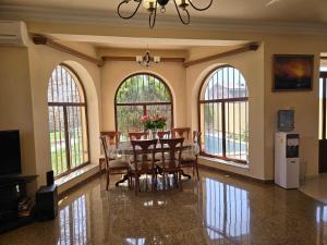 a dining room with a table and chairs and windows at Mery Pery in Yerevan