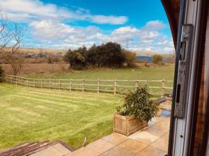 a view of a fence and a field from a window at Jacob's Den Cosy pod with hot tub in Swansea
