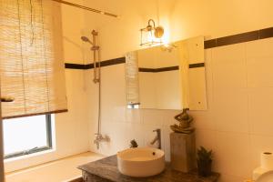 a bathroom with a sink and a tub and a mirror at Villa Jay in Kataragama