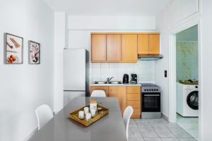 une cuisine avec une table avec des chaises et un réfrigérateur dans l'établissement Ruby house Preveza, à Prévéza