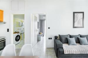 un salon avec un canapé gris et une cuisine dans l'établissement Ruby house Preveza, à Prévéza